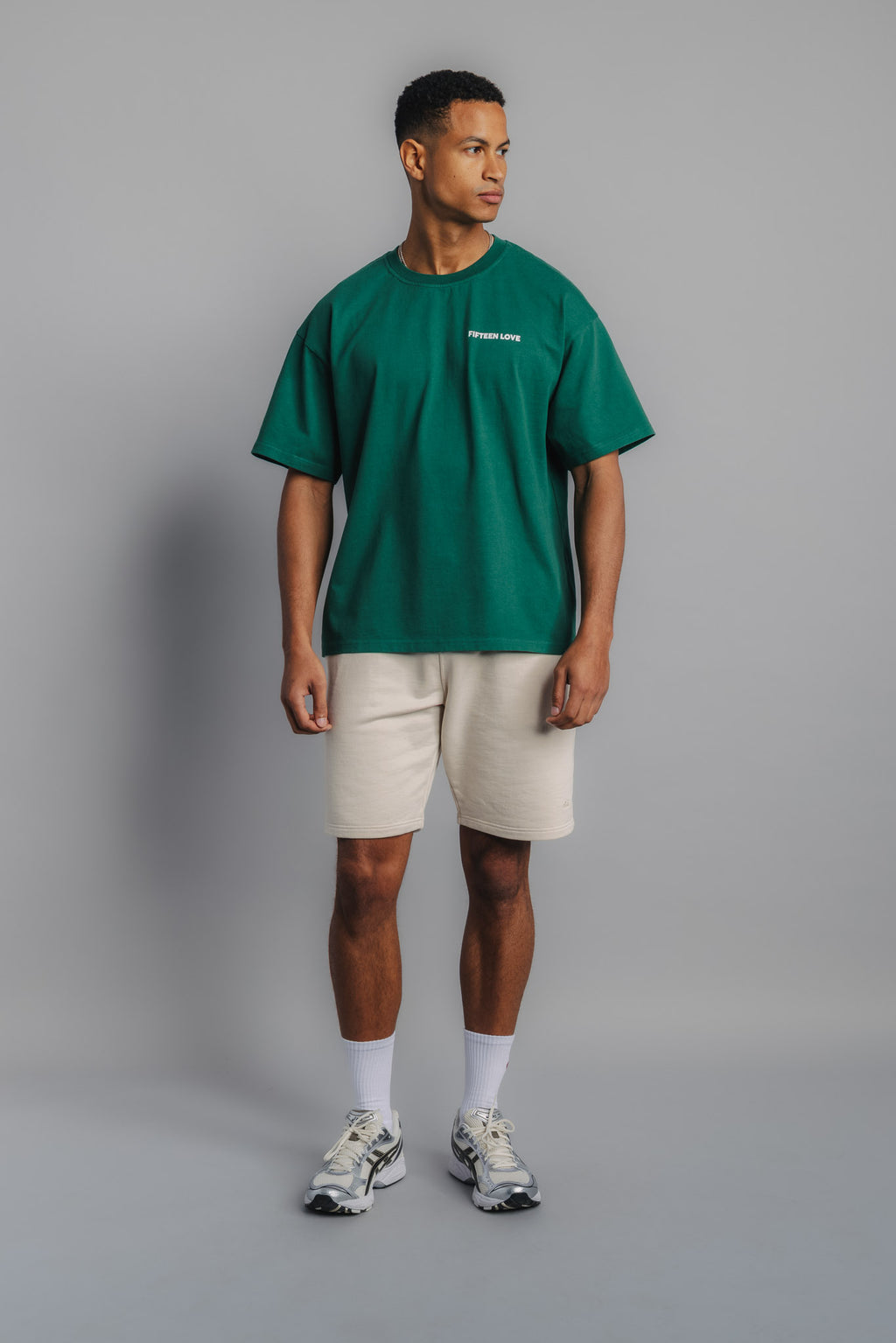 Male model in court green tee with small FL logo embroidery on chest and structured tennis fit.