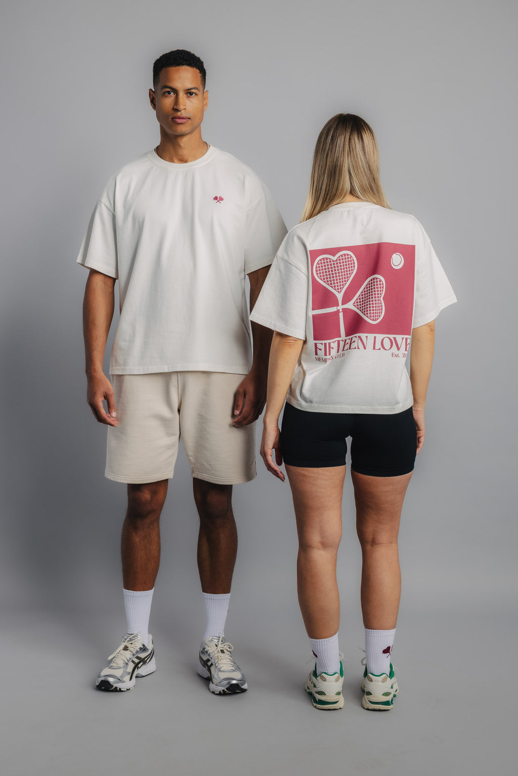 Front and Back view of two tennis models wearing white tennis tees with large heart racquet backprint.